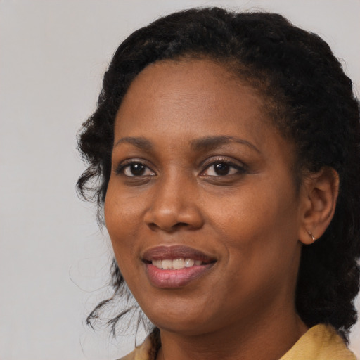Joyful black adult female with medium  black hair and brown eyes