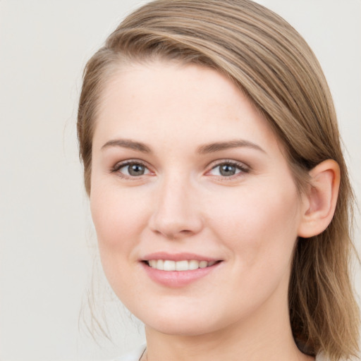 Joyful white young-adult female with medium  brown hair and grey eyes