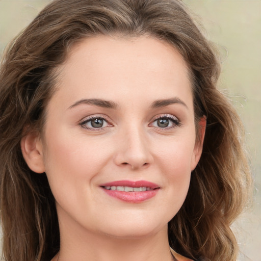 Joyful white young-adult female with long  brown hair and green eyes