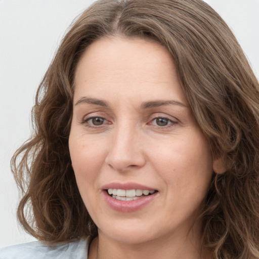 Joyful white adult female with medium  brown hair and green eyes