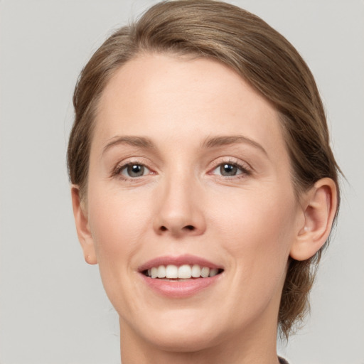 Joyful white young-adult female with medium  brown hair and grey eyes