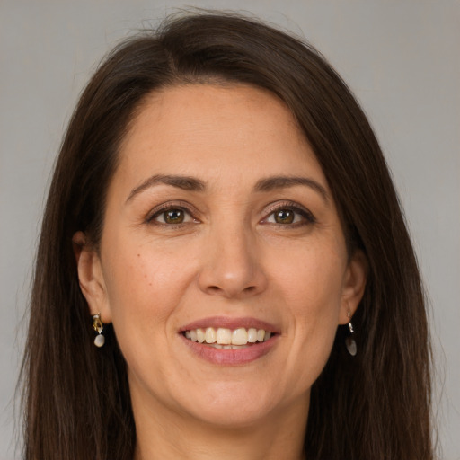 Joyful white adult female with long  brown hair and grey eyes