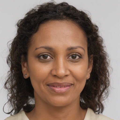 Joyful black young-adult female with medium  brown hair and brown eyes