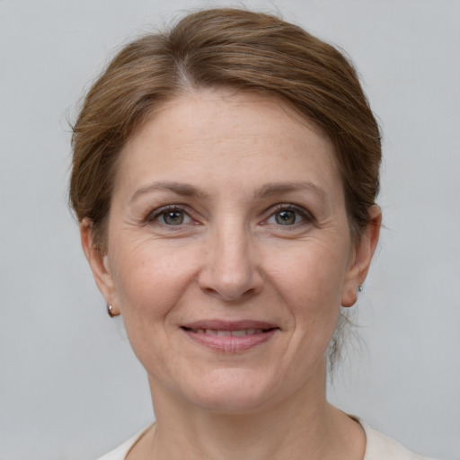 Joyful white adult female with medium  brown hair and grey eyes