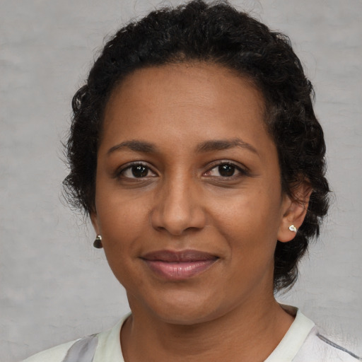 Joyful black adult female with short  brown hair and brown eyes