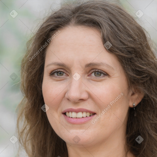 Joyful white adult female with long  brown hair and green eyes