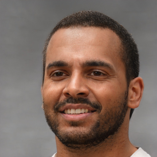 Joyful black young-adult male with short  black hair and brown eyes