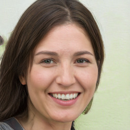 Joyful white adult female with long  brown hair and grey eyes