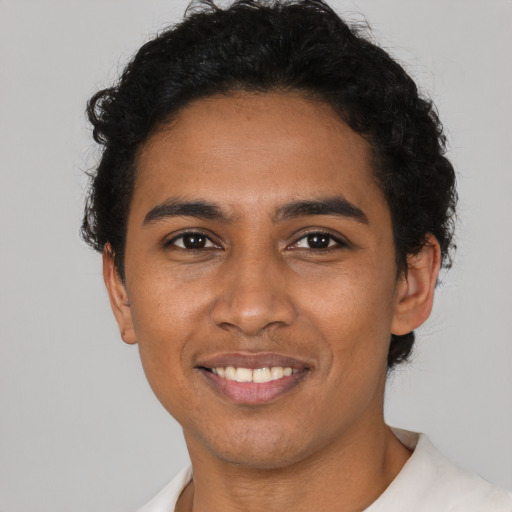 Joyful latino young-adult male with short  black hair and brown eyes