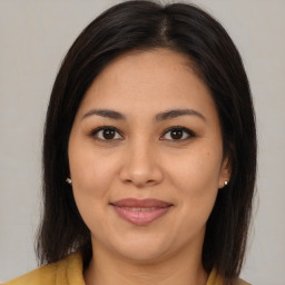 Joyful latino young-adult female with medium  brown hair and brown eyes