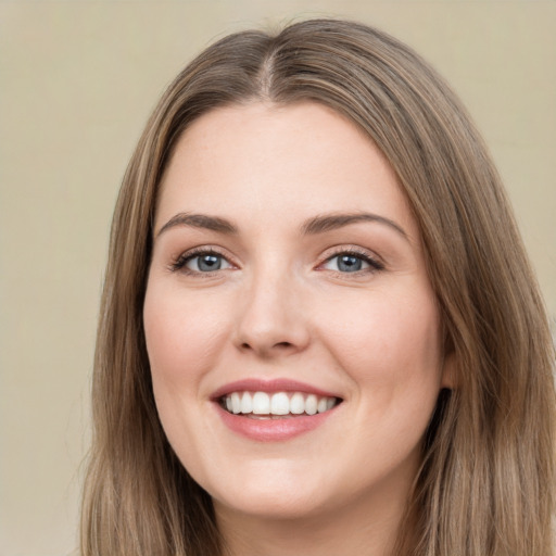 Joyful white young-adult female with long  brown hair and green eyes