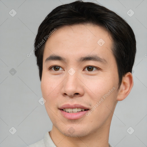 Joyful asian young-adult male with short  brown hair and brown eyes