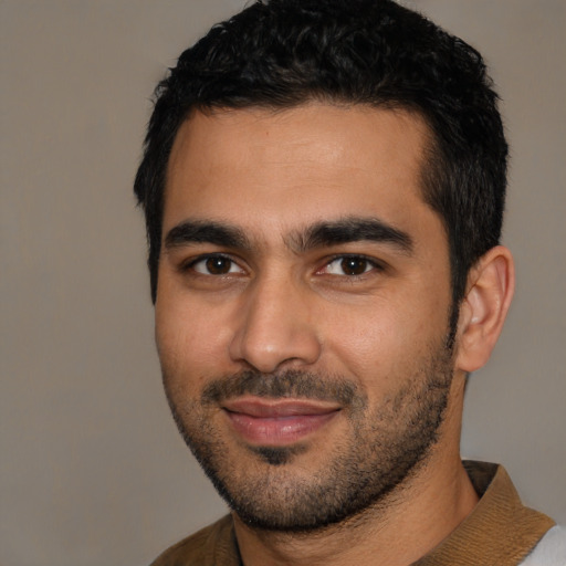 Joyful latino young-adult male with short  black hair and brown eyes