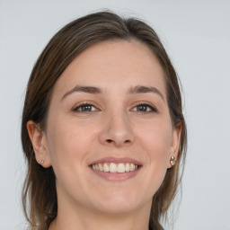 Joyful white young-adult female with medium  brown hair and grey eyes