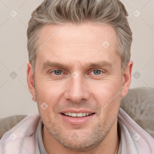 Joyful white adult male with short  brown hair and blue eyes