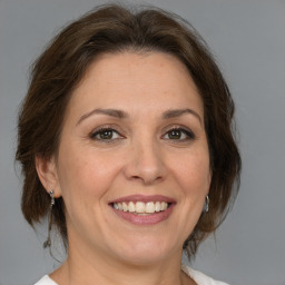 Joyful white adult female with medium  brown hair and brown eyes