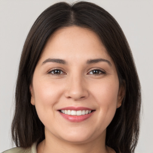 Joyful white young-adult female with long  brown hair and brown eyes