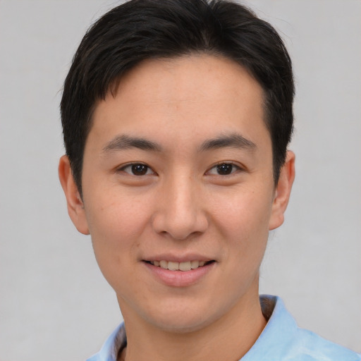 Joyful asian young-adult male with short  brown hair and brown eyes