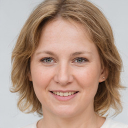 Joyful white young-adult female with medium  brown hair and blue eyes