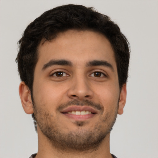 Joyful latino young-adult male with short  brown hair and brown eyes