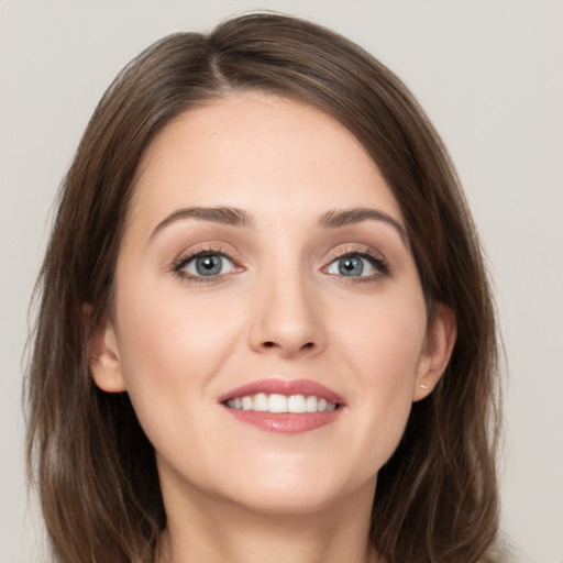 Joyful white young-adult female with long  brown hair and grey eyes