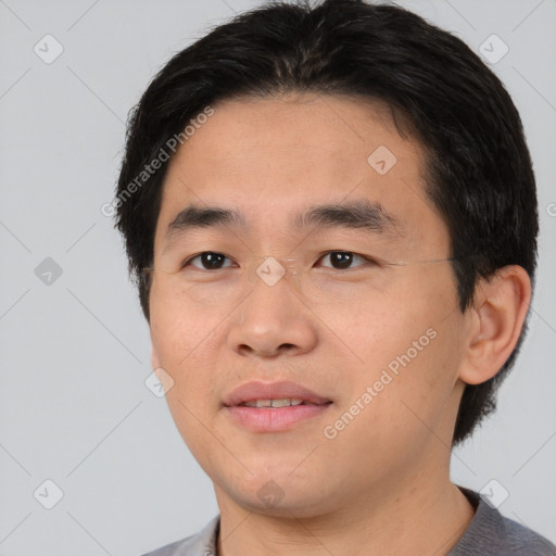 Joyful asian young-adult male with short  black hair and brown eyes