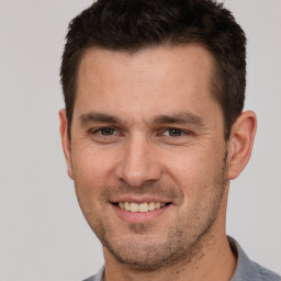 Joyful white adult male with short  brown hair and brown eyes