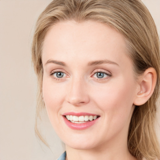 Joyful white young-adult female with long  brown hair and blue eyes