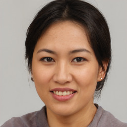 Joyful asian young-adult female with medium  brown hair and brown eyes