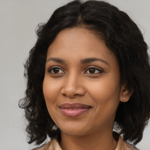 Joyful black young-adult female with long  brown hair and brown eyes