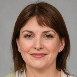 Joyful white adult female with medium  brown hair and grey eyes