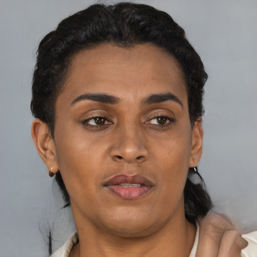 Joyful latino adult female with short  brown hair and brown eyes