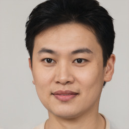 Joyful asian young-adult male with short  black hair and brown eyes