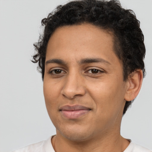 Joyful latino adult male with short  black hair and brown eyes
