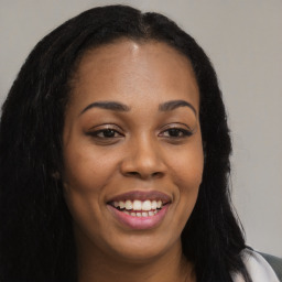 Joyful black young-adult female with long  brown hair and brown eyes