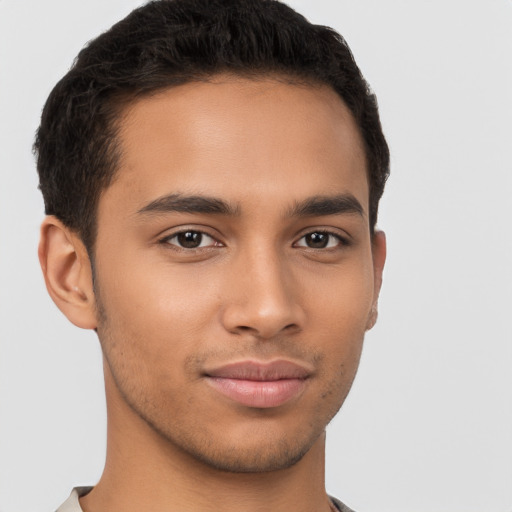 Joyful latino young-adult male with short  brown hair and brown eyes