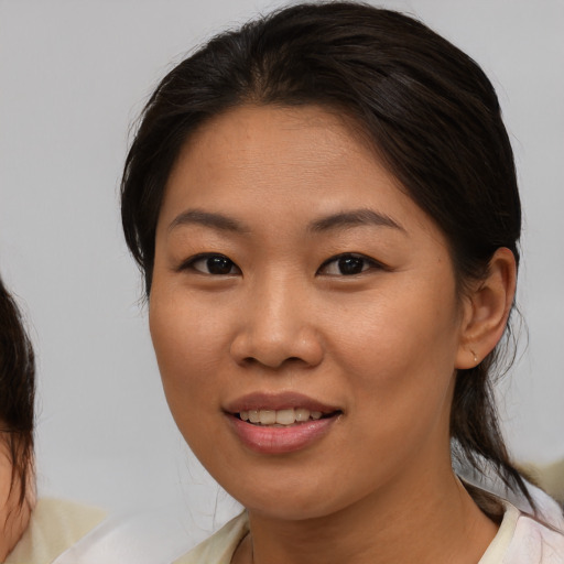 Joyful asian young-adult female with medium  brown hair and brown eyes
