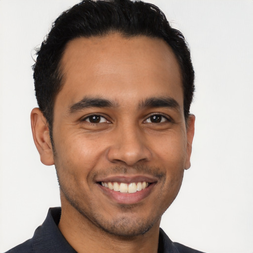 Joyful latino young-adult male with short  brown hair and brown eyes