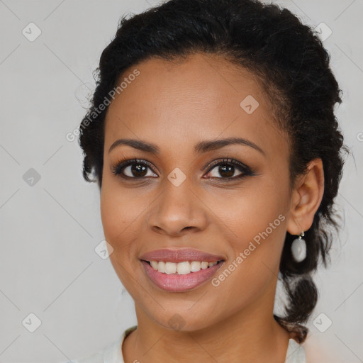 Joyful black young-adult female with long  brown hair and brown eyes