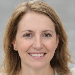 Joyful white adult female with medium  brown hair and grey eyes