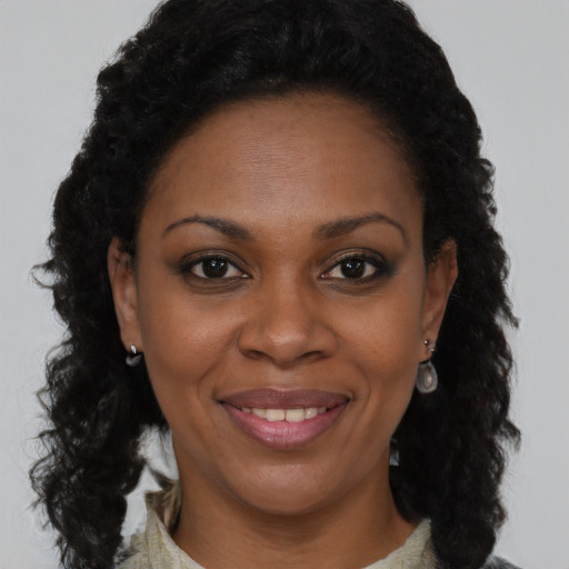Joyful black young-adult female with long  brown hair and brown eyes