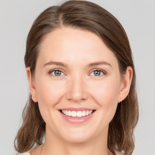 Joyful white young-adult female with medium  brown hair and grey eyes