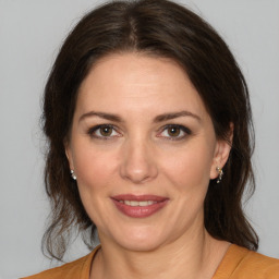 Joyful white adult female with medium  brown hair and brown eyes