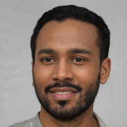 Joyful black young-adult male with short  black hair and brown eyes