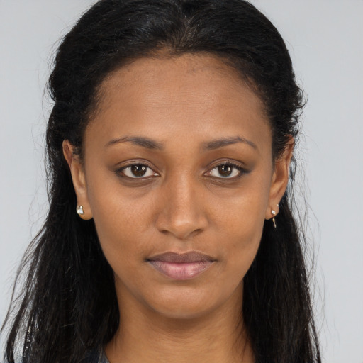 Joyful black young-adult female with long  brown hair and brown eyes