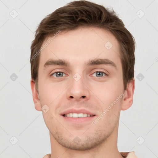 Joyful white young-adult male with short  brown hair and grey eyes