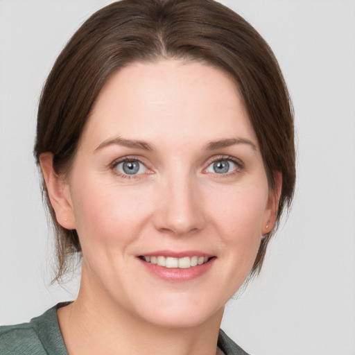 Joyful white young-adult female with medium  brown hair and grey eyes