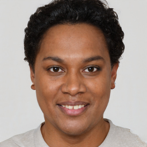 Joyful black young-adult female with short  brown hair and brown eyes