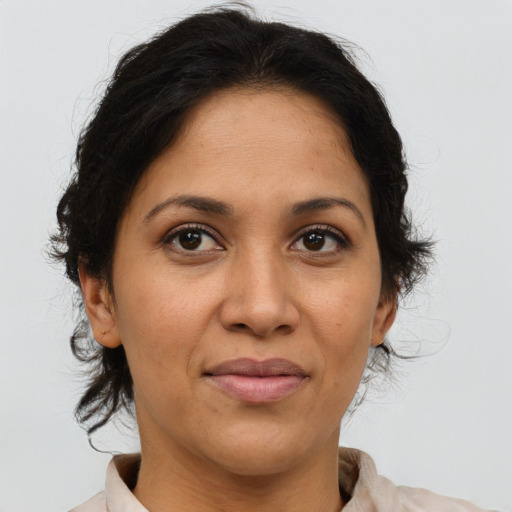 Joyful latino adult female with medium  brown hair and brown eyes