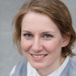 Joyful white young-adult female with medium  brown hair and blue eyes